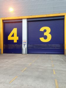 Blue Insulated Roller Shutter Doors in Different Sizes with Yellow Numbers
